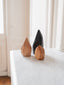 Menhir en bois brut posé sur une table contemporaine