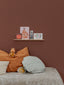 Chambre d'enfant chaleureusement décorée avec une étagère à photos en bois, fabriquée avec soin en Normandie
