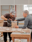 2 artisans ébénistes travaillant ensemble sur la fabrication d'une étagère en bois fait main