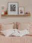 Étagère en bois massif au style minimaliste, judicieusement placée au-dessus du lit, créant un espace de rangement élégant et fonctionnel