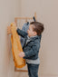 Patères en bois massif normand pour suspendre des vêtements dans une chambre d'enfant, offrant une solution pratique et esthétique